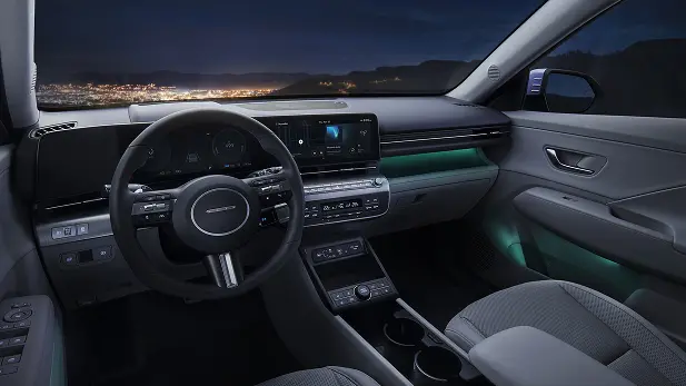 Imagen del interior del Kona Eléctrico una noche con una ciudad en el horizonte