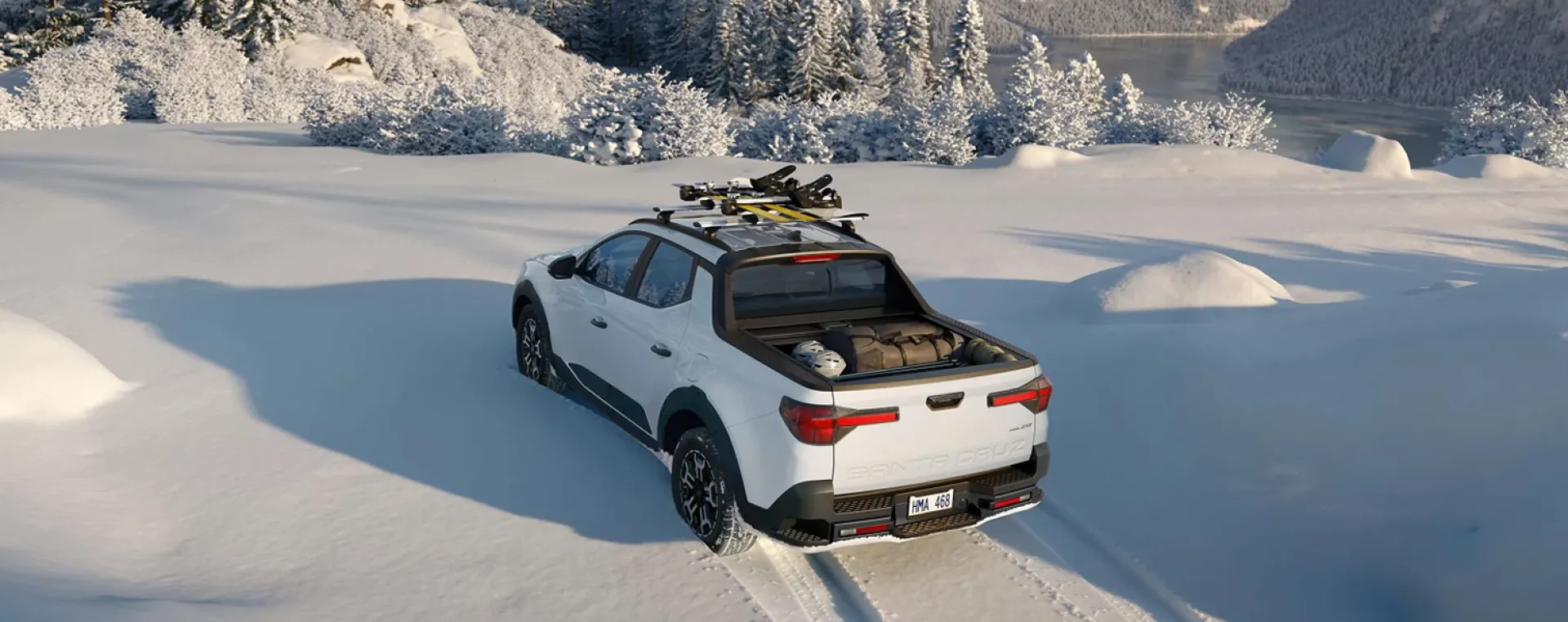Imagen de la Santa Cruz estacionada en la nieve con equipamento de sky en el techo.