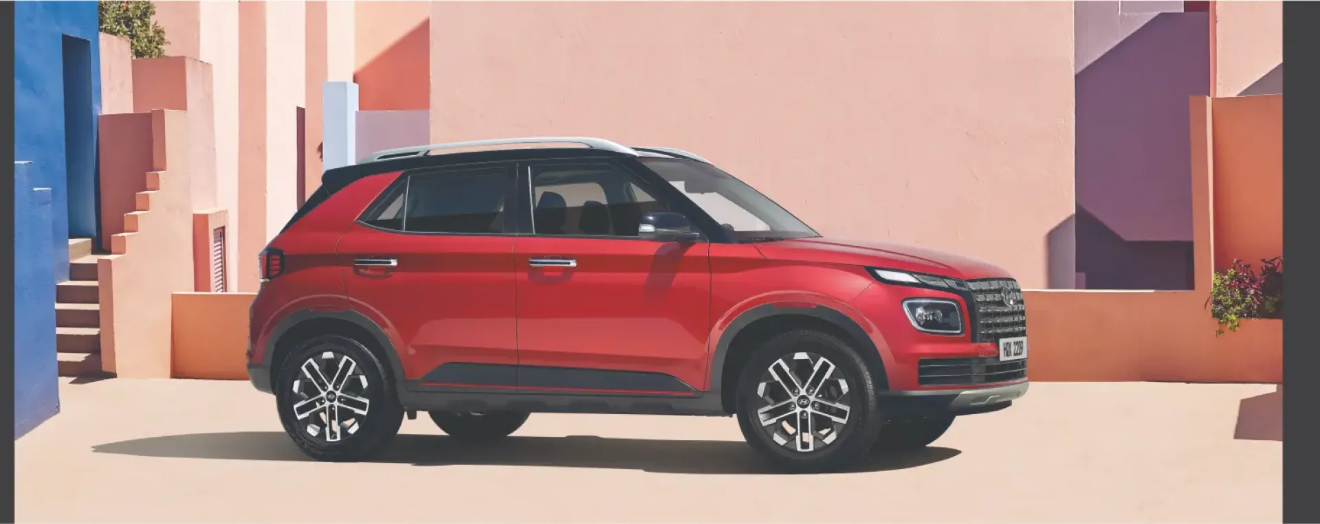 Imagen de un Venue Turbo rojo estacionado un día de sol.